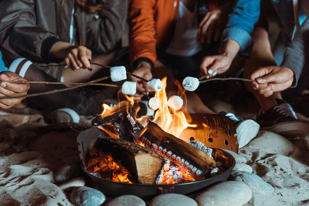 Friends roasting marshmallows on a campfire