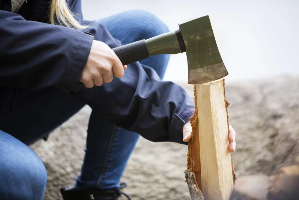 Ax vs. Hatchet vs. Tomahawk : woman cutting wood using a hatchet.