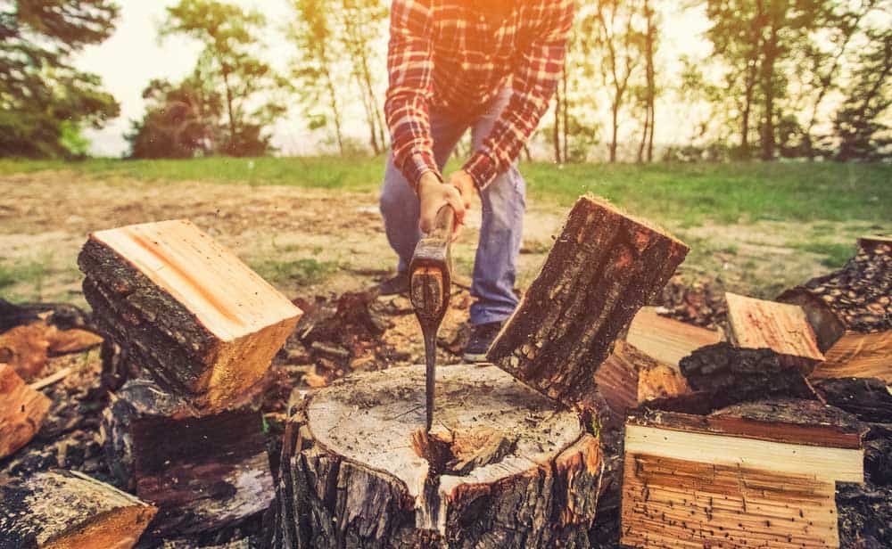 Split firewood with an axe.