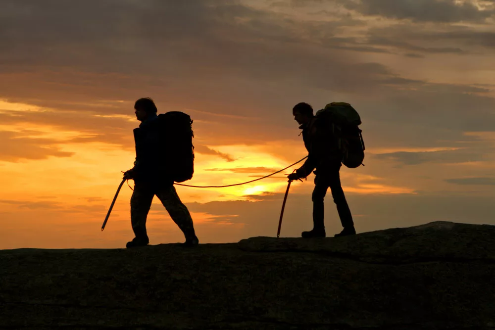 Mountaineers walking using an ice axe