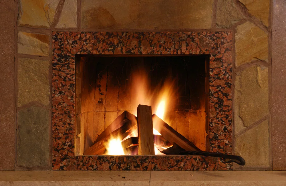 Well-stacked firewood in a fireplace. 