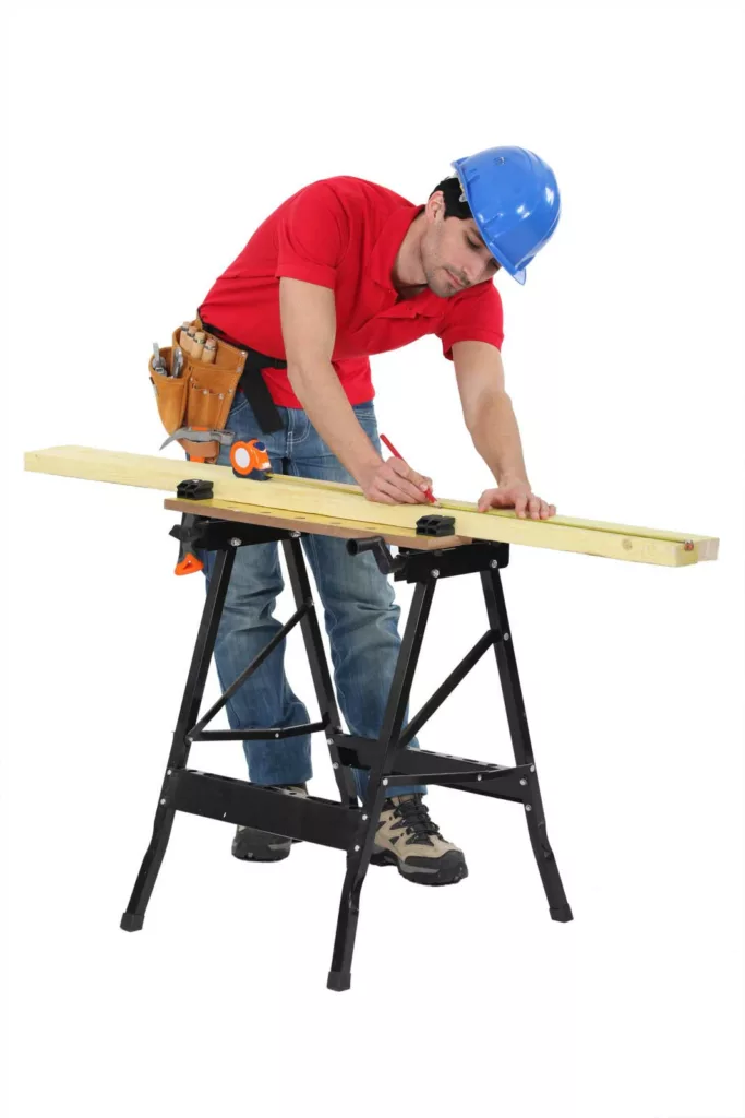 man using sawhorse to measure wood