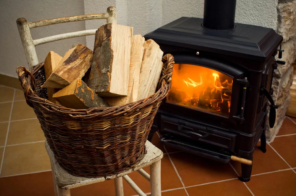 Basket of logs in front of a fireplace