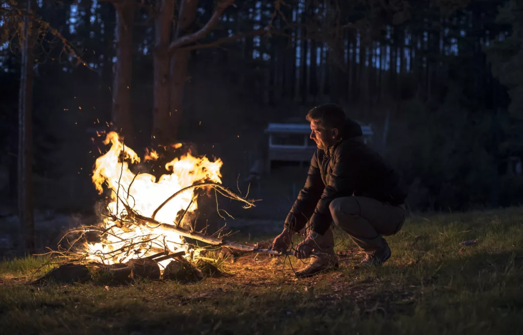 Man lighting a fire in nature.