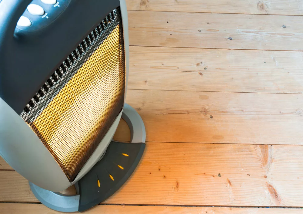 An electric heater on a wooden floor. 