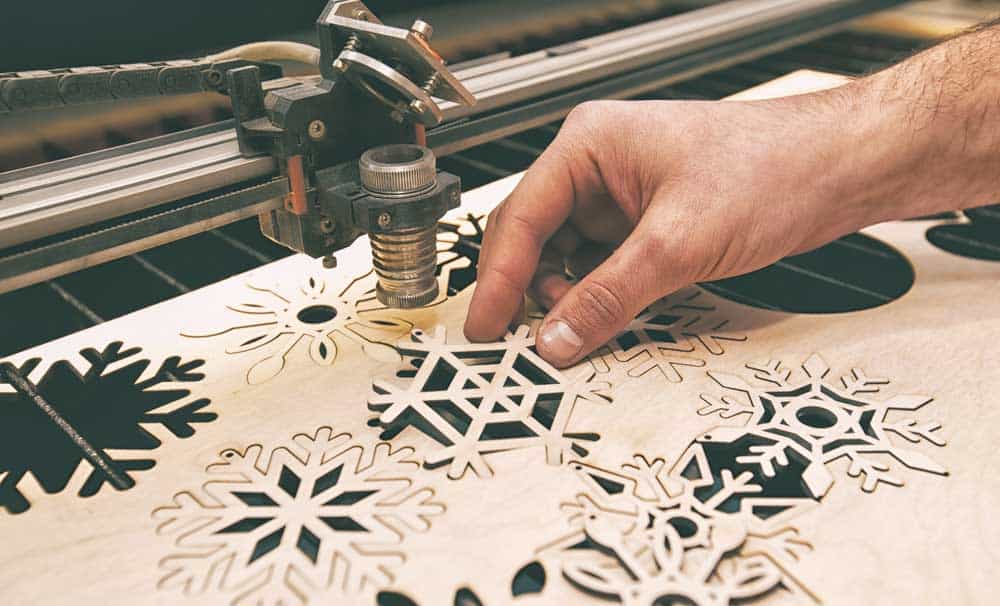 A man making engravings with a laser-cutting machine
